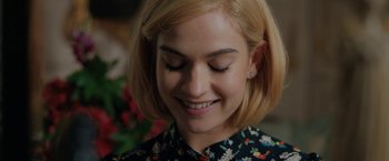 Movie still from “Rebecca” (2020), directed by Ben Wheatley – A person smiling with her eyes closed; Close Up shot, Over the shoulder angle