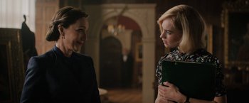 Movie still from “Rebecca” (2020), directed by Ben Wheatley – Two women standing next to each other in front of a doorway; Medium shot, Over the shoulder angle