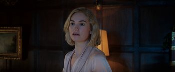 Movie still from “Rebecca” (2020), directed by Ben Wheatley – A beautiful young lady wearing a pink dress; Close Up shot, Over the shoulder angle