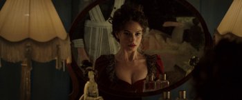 Movie still from “Rebecca” (2020), directed by Ben Wheatley – A woman in a red dress looking into a mirror; Close Up shot, Over the shoulder angle