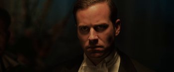 Movie still from “Rebecca” (2020), directed by Ben Wheatley – A person wearing a suit and tie; Close Up shot, Low angle