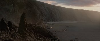Movie still from “Rebecca” (2020), directed by Ben Wheatley – A view of a body of water near a cliff; Extreme Wide shot, High angle