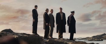 Movie still from “Rebecca” (2020), directed by Ben Wheatley – A group of men standing next to each other on top of a hill; Wide shot, Low angle