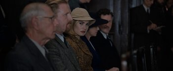 Movie still from “Rebecca” (2020), directed by Ben Wheatley – A group of people sitting next to each other in a room; Close Up shot, Over the shoulder angle
