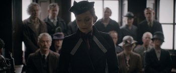 Movie still from “Rebecca” (2020), directed by Ben Wheatley – A woman wearing a hat and a tie; Close Up shot, Over the shoulder angle