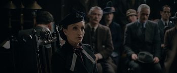Movie still from “Rebecca” (2020), directed by Ben Wheatley – A woman wearing a hat and a tie; Medium shot, Over the shoulder angle