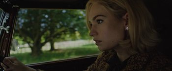 Movie still from “Rebecca” (2020), directed by Ben Wheatley – A woman sitting in a car looking out the window; Close Up shot, Over the shoulder angle