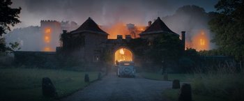 Movie still from “Rebecca” (2020), directed by Ben Wheatley – A car is parked in front of a fire; Extreme Wide shot, High angle