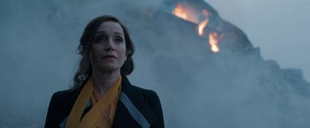 Movie still from “Rebecca” (2020), directed by Ben Wheatley – A woman standing in front of a burning building; Medium shot, Low angle