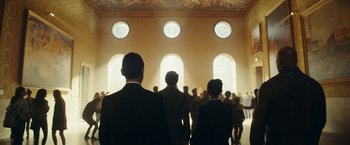 Movie still from “Red Notice” (2021), directed by Rawson Marshall Thurber – A group of people standing in front of a window; Extreme Wide shot, Low angle