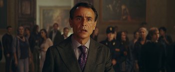 Movie still from “Red Notice” (2021), directed by Rawson Marshall Thurber – A person wearing a suit and tie; Close Up shot, Over the shoulder angle