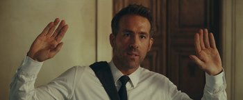 Movie still from “Red Notice” (2021), directed by Rawson Marshall Thurber – A person wearing a shirt and a tie; Close Up shot, Over the shoulder angle