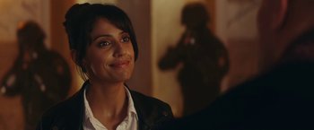 Movie still from “Red Notice” (2021), directed by Rawson Marshall Thurber – A woman smiles at the camera in front of a mirror; Close Up shot, Over the shoulder angle