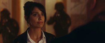 Movie still from “Red Notice” (2021), directed by Rawson Marshall Thurber – A woman in a white dress shirt and a black jacket; Close Up shot, Over the shoulder angle