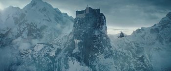 Movie still from “Red Notice” (2021), directed by Rawson Marshall Thurber – A castle on top of a mountain covered in snow; Extreme Wide shot, Low angle
