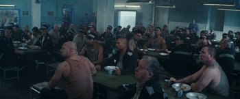 Movie still from “Red Notice” (2021), directed by Rawson Marshall Thurber – A group of people sitting at a table eating; Wide shot, High angle