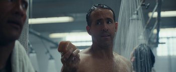 Movie still from “Red Notice” (2021), directed by Rawson Marshall Thurber – A man is taking a shower in the bathroom; Close Up shot, Over the shoulder angle