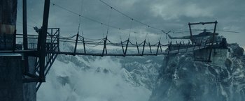 Movie still from “Red Notice” (2021), directed by Rawson Marshall Thurber – A view of a bridge over a snowy mountain; Extreme Wide shot, High angle