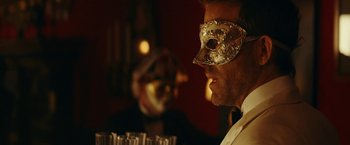 Movie still from “Red Notice” (2021), directed by Rawson Marshall Thurber – A man wearing a gold mask and a white shirt; Close Up shot, Over the shoulder angle