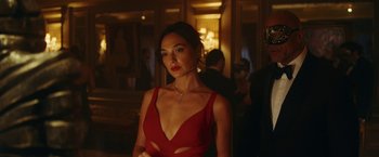 Movie still from “Red Notice” (2021), directed by Rawson Marshall Thurber – A woman in a red dress standing in front of a mirror; Close Up shot, Over the shoulder angle