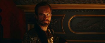 Movie still from “Red Notice” (2021), directed by Rawson Marshall Thurber – A man with a goatee and beard in a dark room; Close Up shot, Low angle