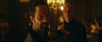 Movie still from “Red Notice” (2021), directed by Rawson Marshall Thurber – A man with a goatee and a beard; Close Up shot, Over the shoulder angle