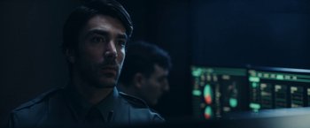 Movie still from “Red Notice” (2021), directed by Rawson Marshall Thurber – A man in a uniform looking at a computer screen; Close Up shot, Over the shoulder angle