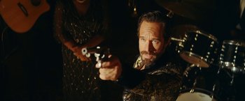 Movie still from “Red Notice” (2021), directed by Rawson Marshall Thurber – A man holding a gun while standing next to a woman; Close Up shot, Over the shoulder angle