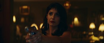 Movie still from “Red Notice” (2021), directed by Rawson Marshall Thurber – A beautiful woman holding a cell phone in her hand; Close Up shot, Over the shoulder angle