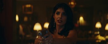 Movie still from “Red Notice” (2021), directed by Rawson Marshall Thurber – A beautiful woman holding a cell phone in her hand; Close Up shot, Over the shoulder angle