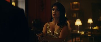 Movie still from “Red Notice” (2021), directed by Rawson Marshall Thurber – A woman in a gold dress holding a gun; Medium shot, Over the shoulder angle