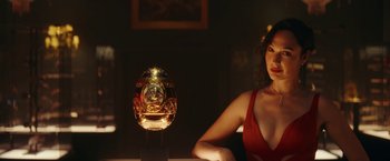 Movie still from “Red Notice” (2021), directed by Rawson Marshall Thurber – A woman sitting in front of a gold fish bowl; Close Up shot, Low angle