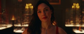 Movie still from “Red Notice” (2021), directed by Rawson Marshall Thurber – A beautiful woman with long dark hair wearing a necklace; Close Up shot, Over the shoulder angle