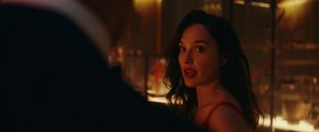 Movie still from “Red Notice” (2021), directed by Rawson Marshall Thurber – A beautiful young lady sitting at a table; Close Up shot, Over the shoulder angle