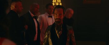 Movie still from “Red Notice” (2021), directed by Rawson Marshall Thurber – A group of men standing in a dark room; Medium shot, Over the shoulder angle