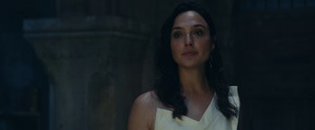 Movie still from “Red Notice” (2021), directed by Rawson Marshall Thurber – A woman in a white dress is looking at the camera; Close Up shot, Over the shoulder angle