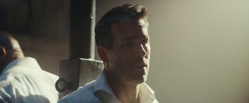 Movie still from “Red Notice” (2021), directed by Rawson Marshall Thurber – A person wearing a white shirt; Close Up shot, Low angle