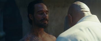 Movie still from “Red Notice” (2021), directed by Rawson Marshall Thurber – A person with a tattoo on his face; Close Up shot, Over the shoulder angle