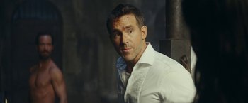 Movie still from “Red Notice” (2021), directed by Rawson Marshall Thurber – A person wearing a white shirt; Close Up shot, Over the shoulder angle