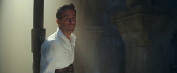 Movie still from “Red Notice” (2021), directed by Rawson Marshall Thurber – A man wearing a white shirt and a brown belt; Medium shot, Low angle