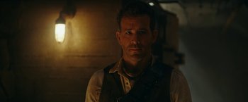 Movie still from “Red Notice” (2021), directed by Rawson Marshall Thurber – A person wearing a shirt and tie; Close Up shot, Over the shoulder angle