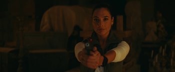 Movie still from “Red Notice” (2021), directed by Rawson Marshall Thurber – A woman is holding a gun in a room; Close Up shot, Over the shoulder angle