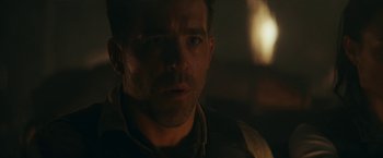 Movie still from “Red Notice” (2021), directed by Rawson Marshall Thurber – A man's face in the dark; Close Up shot, Over the shoulder angle