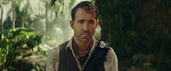 Movie still from “Red Notice” (2021), directed by Rawson Marshall Thurber – A person wearing a vest and holding a camera; Close Up shot, Over the shoulder angle