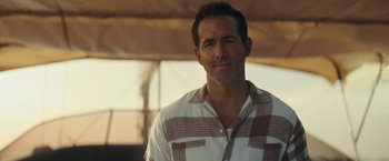 Movie still from “Red Notice” (2021), directed by Rawson Marshall Thurber – A person wearing a plaid shirt; Close Up shot, Over the shoulder angle