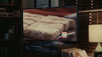 Movie still from “Reptile” (2023), directed by Grant Singer – A television screen with a bunch of packages on it; Extreme Close Up shot, High angle