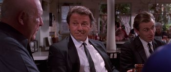 Movie still from “Reservoir Dogs” (1992), directed by Quentin Tarantino – A person wearing a suit and tie; Medium shot, Low angle