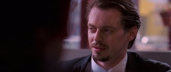 Movie still from “Reservoir Dogs” (1992), directed by Quentin Tarantino – A person wearing a suit and tie; Close Up shot, Over the shoulder angle