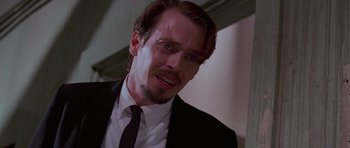 Movie still from “Reservoir Dogs” (1992), directed by Quentin Tarantino – A person wearing a suit and tie; Close Up shot, Low angle