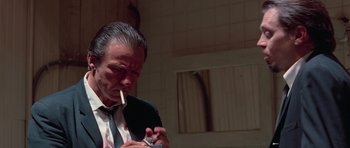 Movie still from “Reservoir Dogs” (1992), directed by Quentin Tarantino – An older man smoking a cigarette while holding a cell phone; Close Up shot, Low angle